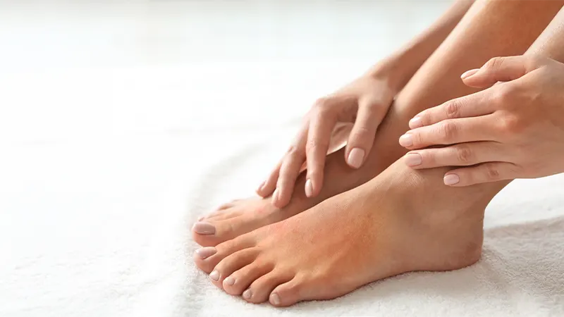 Close-up of person holding a foot and ankle with highlighted area indicating discomfort and inflammation.